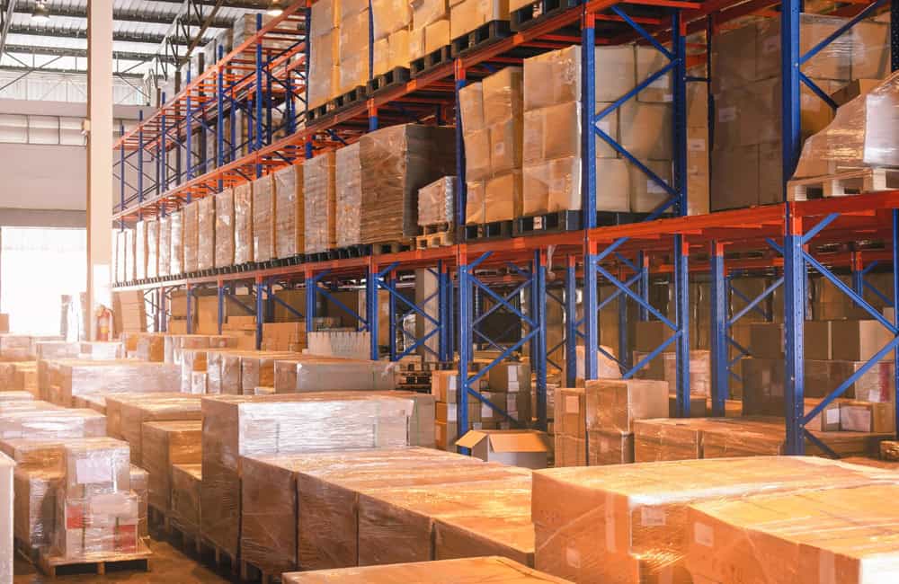 Warehouse with stacked boxes and shelving for supply chain management.