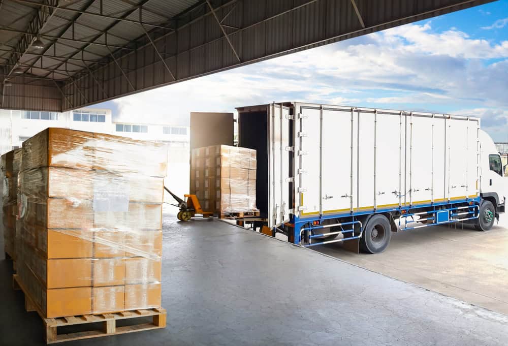 Warehouse with pallets and a truck ready for freight shipping logistics.