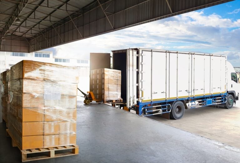 Container truck parked at loading dock, loading packages into truck