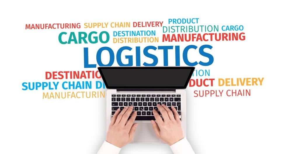 Hands typing on a laptop with logistics and supply chain keywords around it.